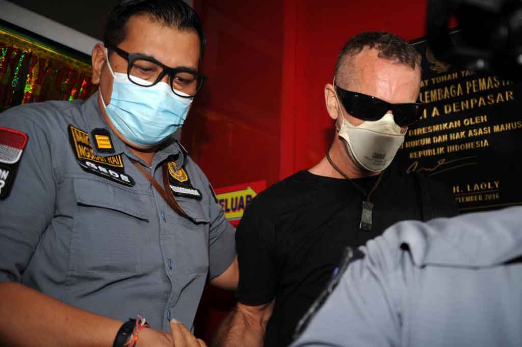 Warga negara Inggris David Taylor dengan pengawalan petugas imigrasi meninggalkan Lapas Kerobokan di Bali, Kamis, 11 Februari 2021.