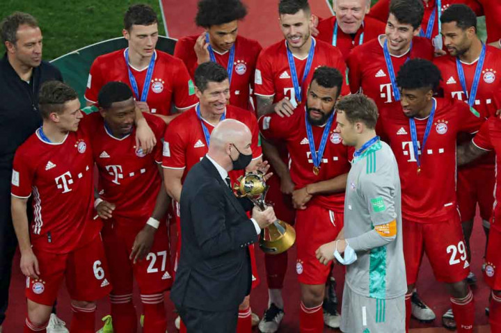 Presiden FIFA Gianni Infantino (tengah) mempersembahkan trofi Piala Dunia Antarklub kepada kiper sekaligus kapten tim Bayern Munich Manuel Neuer menyusul pertandingan final antara Bayern melawan UANL Tigres Meksiko di Stadion Education City, Al Rayyan, Qatar, Jumat, 12 Februari 2021 dini hari WIB.
