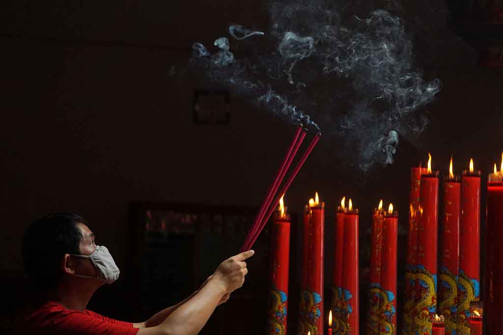 Umat Tri Dharma tengah beribadah di Kelenteng Hok Tek Bio, Purwokerto, Jawa Tengah (Jateng) pada perayaan Tahun Baru Imlek 2572, Jumat, 12 Februari 2021. Mereka berdoa secara pribadi dan menyalakan lilin. 