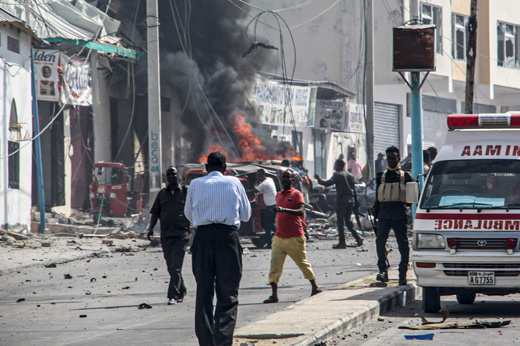 Petugas keamanan berdiri di sekitar lokasi serangan bom mobil di dekat pos pemeriksaan keamanan di Mogadishu, Somalia, pada Sabtu, 13 Februari 2021.