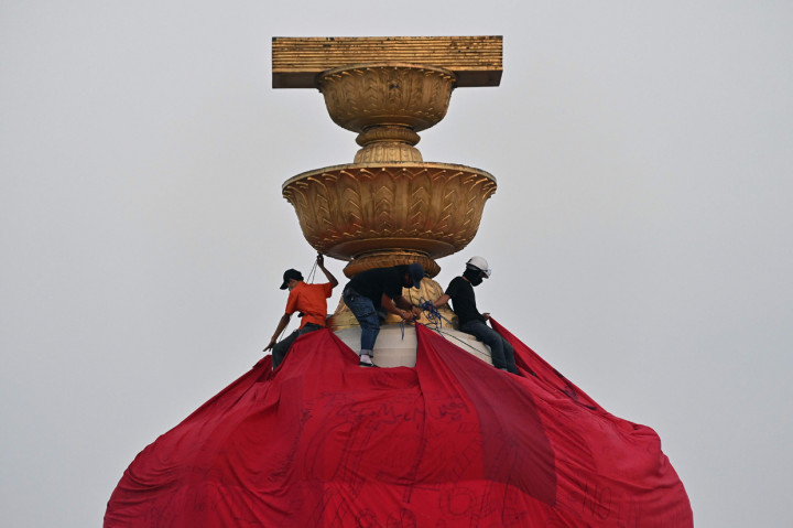 Mereka terlibat bentrok dengan polisi setelah menutup Monumen Demokrasi Bangkok dengan kain berwarna merah.