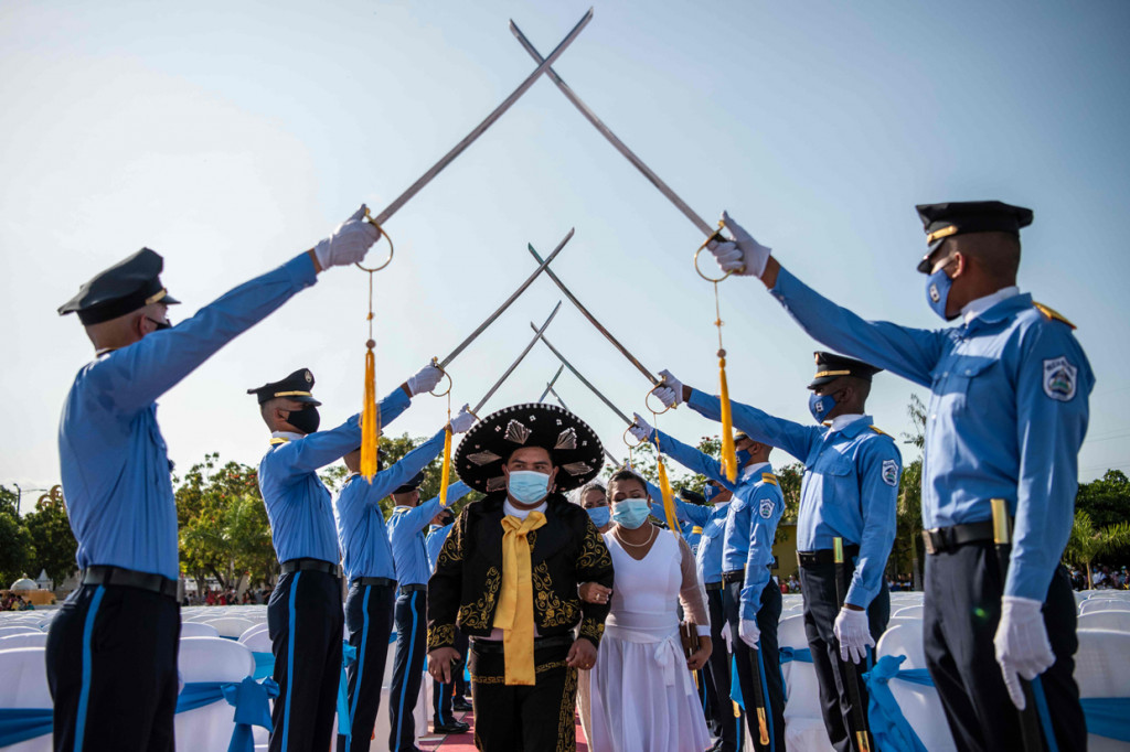 Pasangan pengantin melewati barisan prajurit saat disambut dengan upacara militer dalam nikah massal yang digelar pada Hari Valentine.