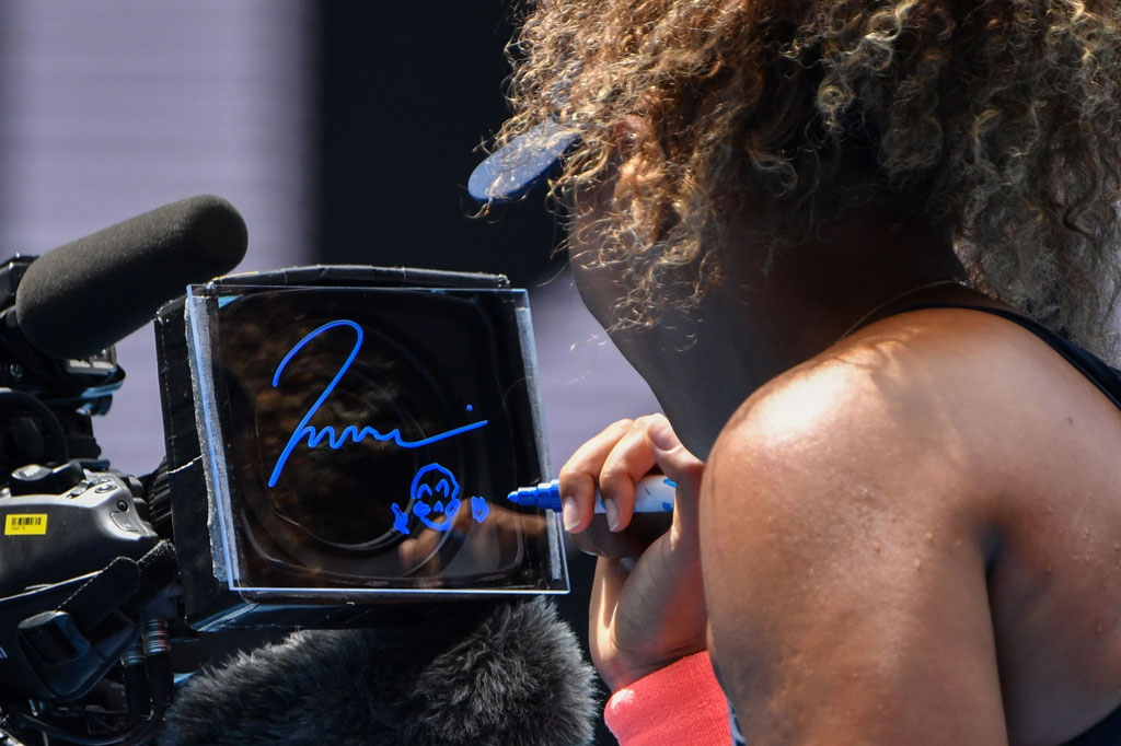 Naomi Osaka membubuhkan tanda tangan di kamera TV setelah meraih kemenangan atas Hsieh Su-wei Taiwan dalam pertandingan perempat final tunggal putri turnamen tenis Australia Open 2021 di Melbourne pada Selasa, 16 Februari 2021.