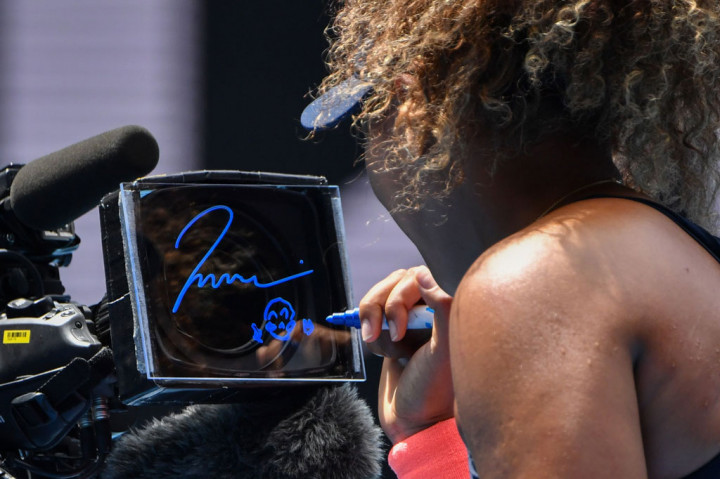 Naomi Osaka membubuhkan tanda tangan di kamera TV setelah meraih kemenangan atas Hsieh Su-wei Taiwan dalam pertandingan perempat final tunggal putri turnamen tenis Australia Open 2021 di Melbourne pada Selasa, 16 Februari 2021.