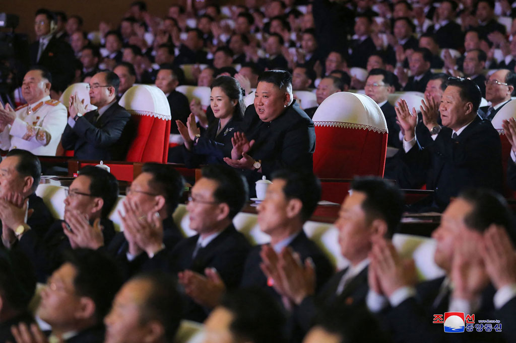 Ri dan Kim tersenyum saat mereka menonton konser di Teater Seni Mansudae di ibu kota Pyongyang. Tidak seperti pada beberapa acara sebelumnya, tidak ada satu orang pun dalam foto yang diterbitkan oleh Rodong Sinmun yang tampak mengenakan masker atau melakukan tindakan jaga jarak sosial.