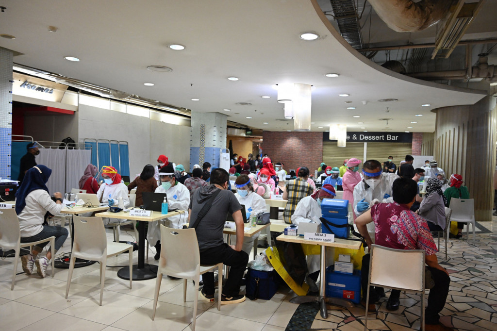 Menurut keterangan petugas, pedagang yang datang dan dijadwalkan menerima vaksin hari ini sudah diberikan kupon pendaftaran sejak kemarin. AFP Photo/Adek Berry