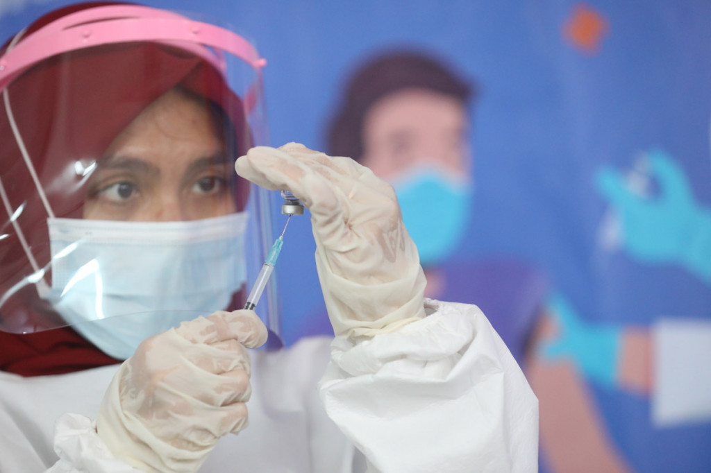 Petugas medis memasukkan cairan vaksinasi Covid-19 ke jarum suntik di Pasar Tanah Abang, Jakarta. MI/Ramdani
