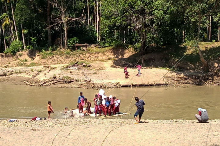 Anak-anak murid SD Siron menyeberangi Sungai Murtala di  Desa Siron Blang, Kecamatan Kuta Cot Glie, Kabupaten Aceh Besar, Aceh, dengan menaiki rakit buatan, Rabu, 17 Februari 2021.