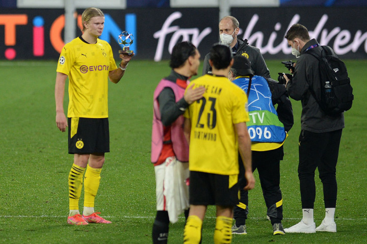 Pemain depan Dortmund asal Norwegia Erling Braut Haaland (kiri) berpose dengan man of the match trophy di akhir pertandingan leg pertama babak 16 besar Liga Champions UEFA antara Sevilla FC dan Borussia Dortmund di stadion Ramon Sanchez Pizjuan.
