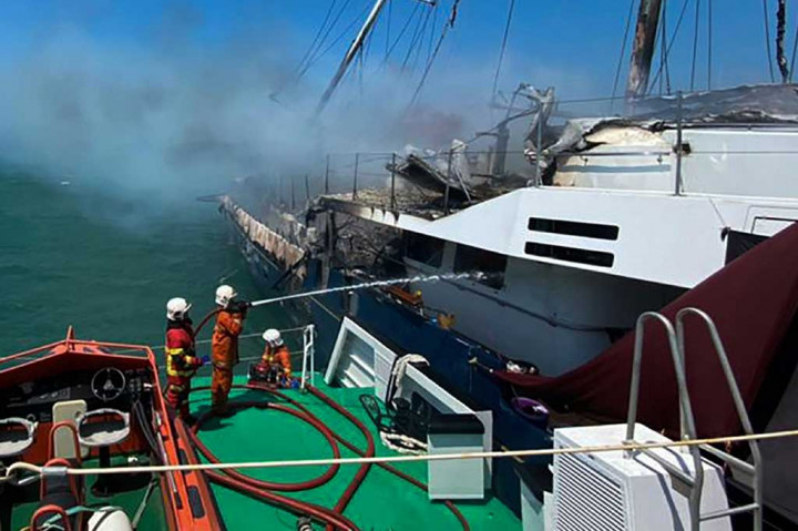 Petugas pemadam masih terus melakukan pembasahan di kapal pesiar yang terbakar, sementara  penyebab kebakaran belum diketahui.