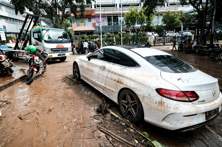 Meski banjir telah surut, kini lumpur memenuhi kawasan elite di Jakarta Selatan tersebut.