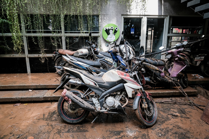 Terlihat jalanan dan area sekitar pertokoan masih dipenuhi oleh lumpur. Air masih tampak mengalir dari salah satu bangunan yang berlokasi di kawasan ini.