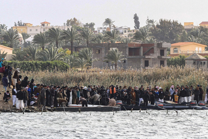 Kerabat korban kapal terbalik berkumpul di pinggir Danau Mariout, 20 kilometer (12 mil) barat kota Alexandria, Mesir, pada Selasa, 23 Februari 2021, ketika tim SAR melakukan operasi penyelamatan.