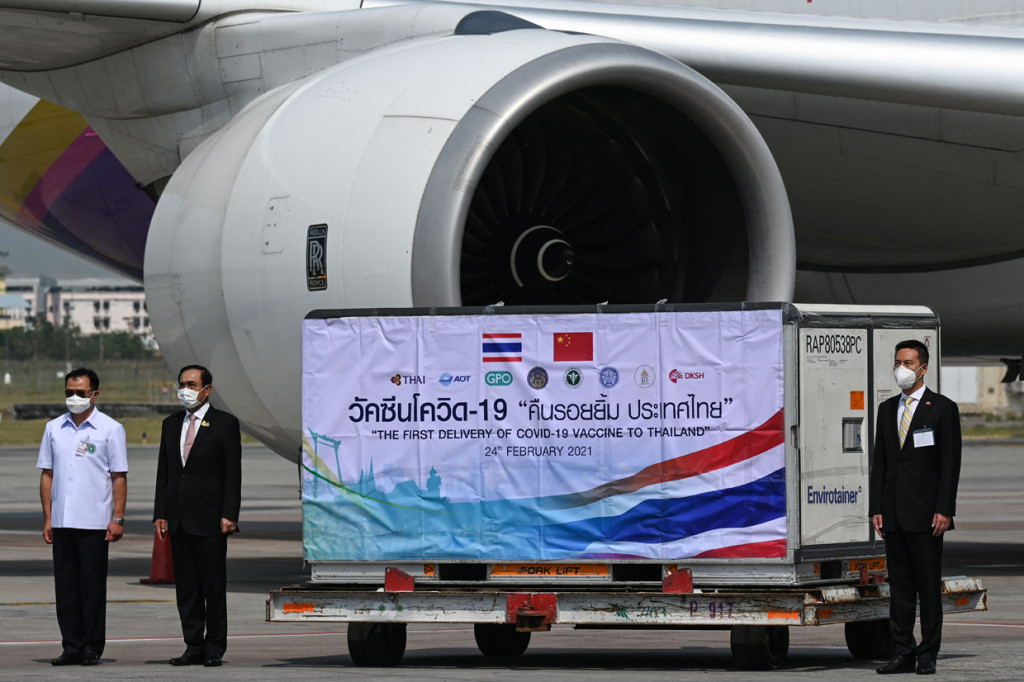Perdana Menteri Thailand Prayut Chan-O-Cha (tengah), Menteri Kesehatan Anutin Charnvirakul (kiri) dan Yang Xin, Kuasa Usaha Kedutaan Besar Tiongkok, berdiri di samping pengiriman vaksin virus corona Coronavac Covid-19, yang dikembangkan oleh Sinovac setelah tiba di Bangkok.