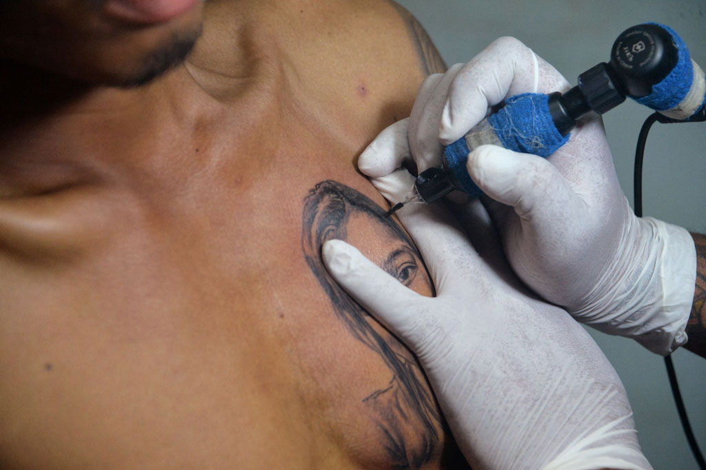 Seniman tato mengukir tato di dada Hein Yar Zar, pacar pengunjuk rasa Myanmar Mya Thwate Thwate Khaing, yang meninggal setelah ditembak pasukan keamanan Myanmar saat unjuk rasa menentang kudeta militer, Rabu, 24 Februari 2021.