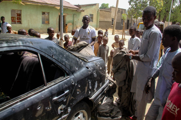 Penduduk mengelilingi bangkai mobil yang terkena serangan oleh anggota jihadis Boko Haram di distrik Adam Kolo, Maiduguri pada Rabu, 24 Februari 2021.