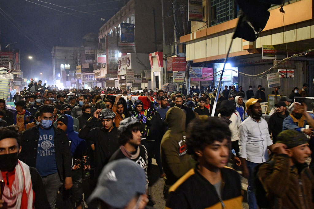 Pengunjuk rasa anti-pemerintah membawa peti mati palsu selama demonstrasi yang menyerukan pengunduran diri Gubernur Nazem al-Waeli dan menentang layanan publik yang memburuk di Kota Nasiriyah, Provinsi Dhi Qar, Irak selatan, pada Jumat, 26 Februari 2021.