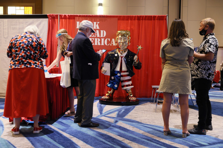 Patung tersebut dalam balutan jas setelan merek dagang Trump dengan celana pendek bertema bendera Amerika dan sandal jepit.