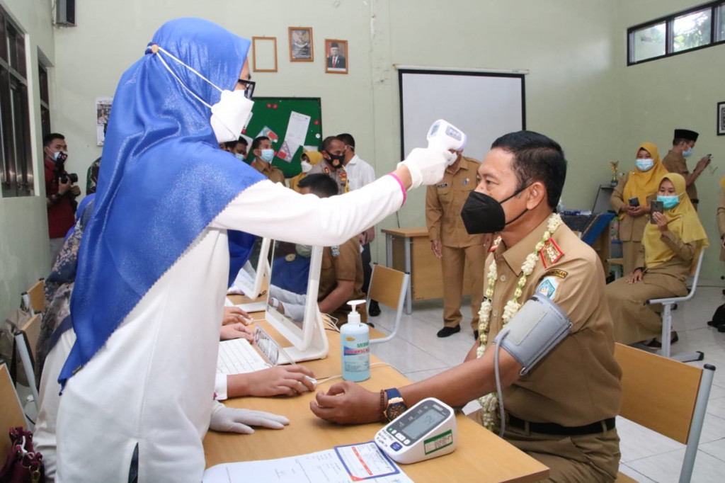 Bupati Lamongan, Yuhronur Efendi langsung menjalani vaksinasi Covid-19 di hari pertamanya kerja. Vaksinasi lakukan di Sekolah Menengah Pertama (SMP) Negeri 1 Lamongan, Senin, 1 Februari 2021.