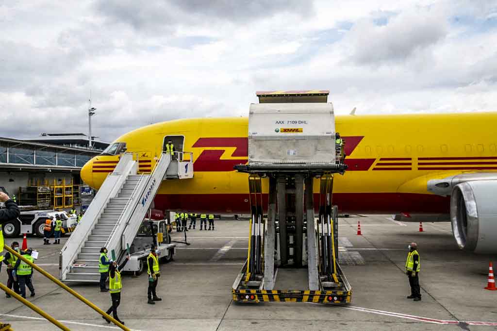 Pekerja bandara tengah membongkar sebanyak 117.000 dosis vaksin covid-19 melalui mekanisme Covax, di bandara internasional El Dorado, di Bogota, pada Senin, 1 Maret 2021.
