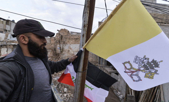 Pekerja mengibarkan bendera Irak dan Takhta Suci Vatikan di tiang-tiang jalan di kota Mosul, Irak, Kamis, 4 Maret 2021.
