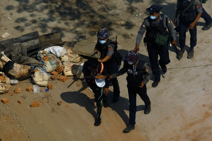 Polisi membawa seorang pengunjuk rasa saat mereka menahannya selama demonstrasi menentang kudeta militer di Yangon.