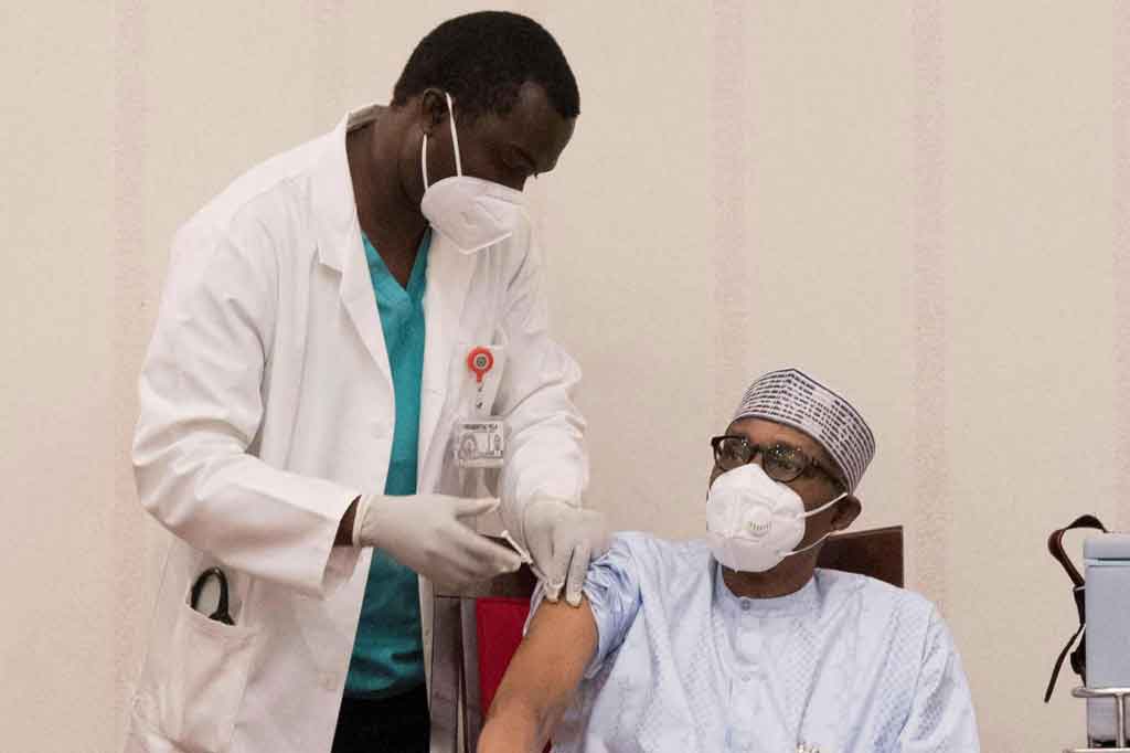 Presiden Nigeria Muhammadu Buhari (tengah) menerima dosis pertama vaksin Oxford / AstraZeneca Covid-19 di vila kepresidenan di Abuja, pada Sabtu, 6 Maret 2021 waktu setempat.