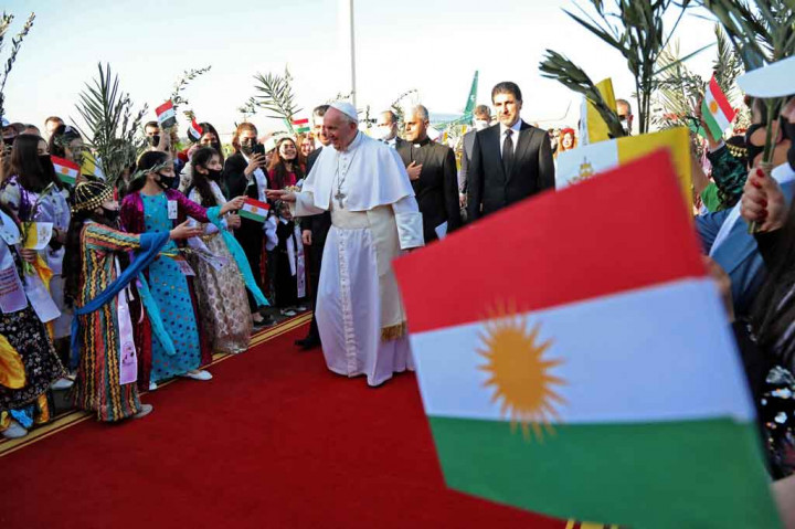 Paus Fransiskus menyapa warga Irak yang mengenakan pakaian tradisional setibanya di Bandara Arbil, di ibu kota wilayah otonom Kurdi Irak utara  pada Minggu, 7 Maret 2021.