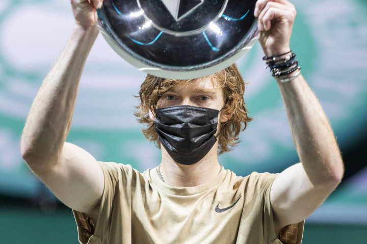 Petenis Rusia Andrey Rublev mengangkat trofi yang baru saja dia raih usai menjuarai turnamen Rotterdam Open 2021.