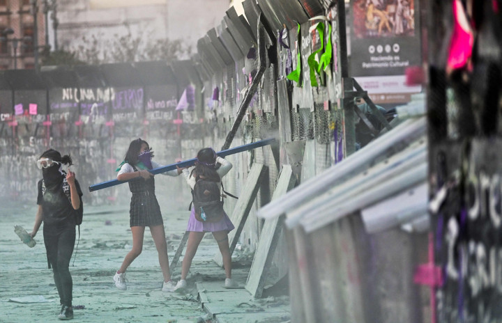 Demonstran menyerang barikade yang melindungi Istana Nasional selama pawai memperingati Hari Perempuan Internasional dan memprotes kekerasan gender di Mexico City, Meksiko.