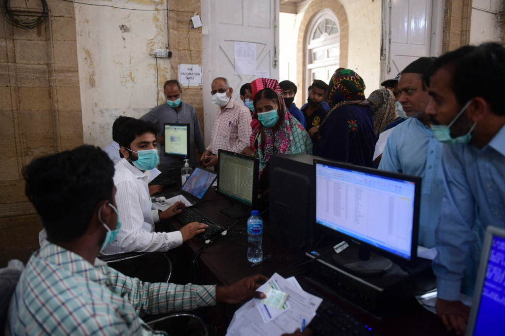 Petugas kesehatan mengumpulkan informasi dari orang-orang sebelum melakukan vaksin virus korona Sinopharm, di pusat vaksinasi, di Karachi, Pakistan, Rabu, 10 Maret 2021.