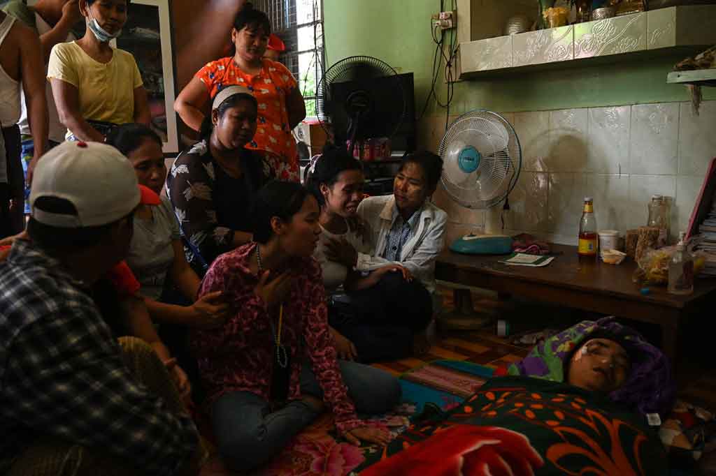 Keluarga tidak kuasa menahan tangis di samping jenazah mendiang Chit Min Thu, korban yang ditembak di kepala oleh pasukan keamanan saat berdemonstrasi menentang kudeta militer di Yangon pada Kamis, 11 Maret 2021.