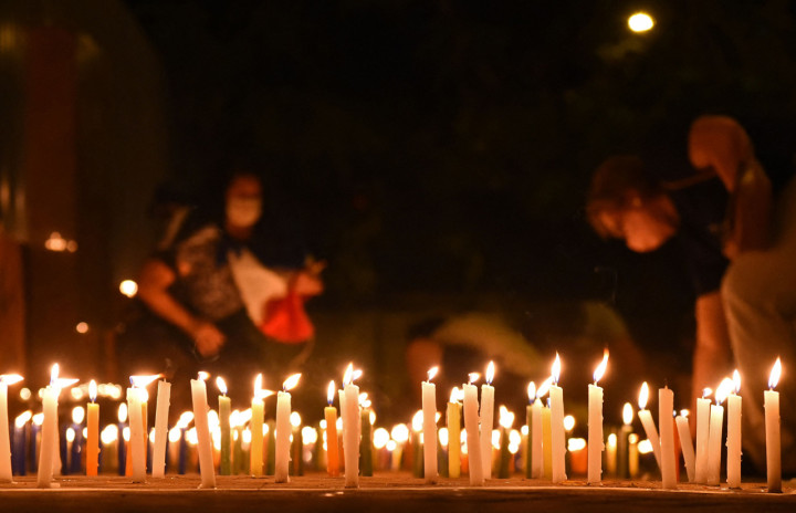 Orang-orang menyalakan lilin untuk mengenang mereka yang meninggal akibat virus korona di depan Kementerian Kesehatan di Asuncion, Paraguay.