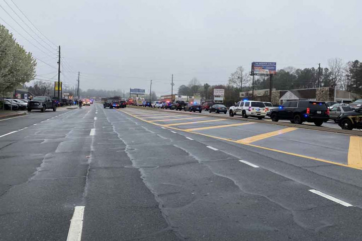 Barisan mobil penegak hukum memblokade area penembakan di spa di pinggiran Atlanta, Georgia, AS pada Selasa, 16 Maret 2021. Sedikitnya tujuh orang meninggal dunia dalam penembakan di tiga spa berbeda di negara bagian Georgia.