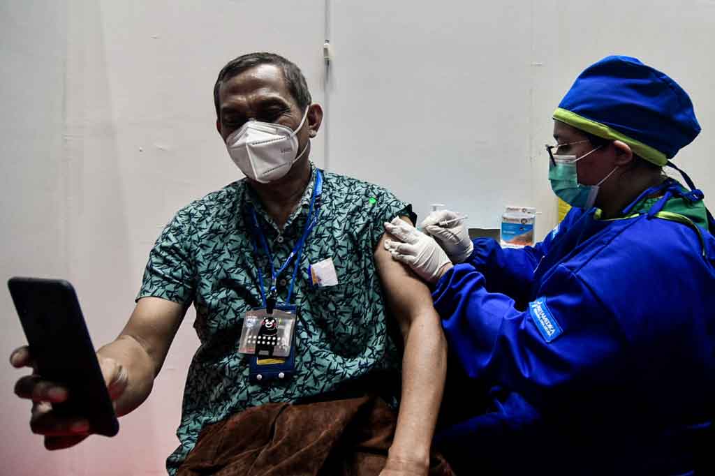 Warga lansia menerima vaksinasi saat kegiatan Sentra Vaksinasi Bersama Covid-19 di Istora Senayan, Jakarta, Rabu, 17 Maret 2021.