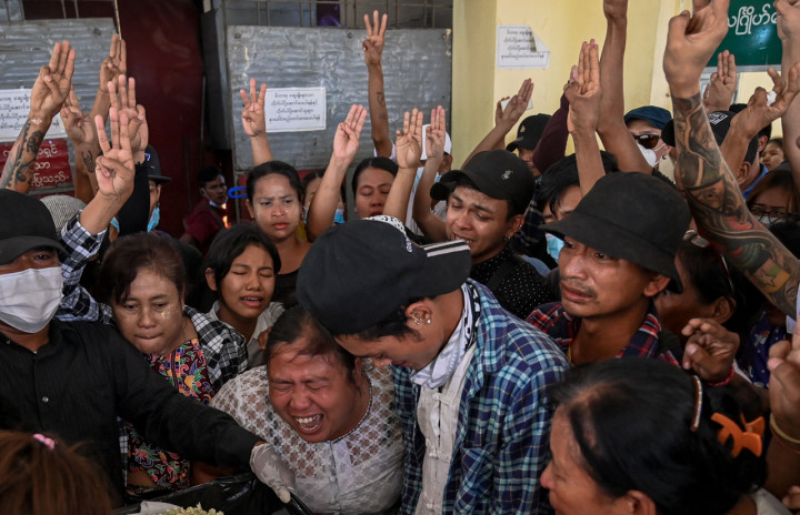 Ibu dari pengunjuk rasa remaja Aung Kaung Htet bereaksi dengan peti mati, saat para pelayat mengacungkan salam tiga jari saat pemakamannya di Yangon.