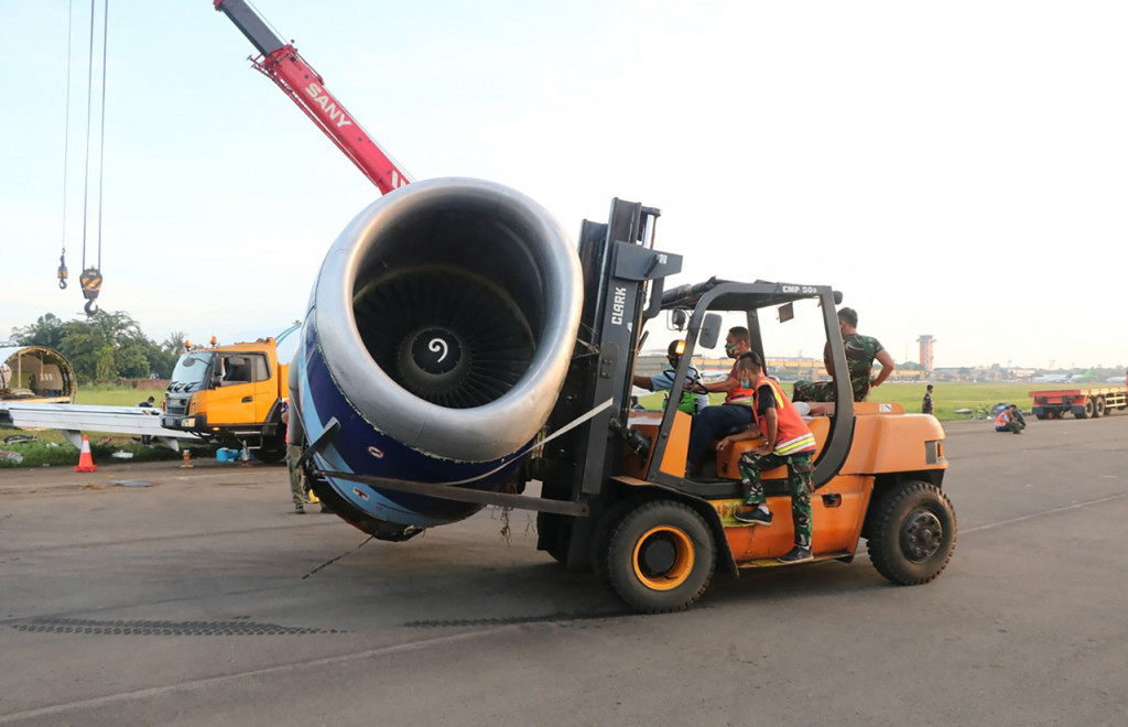 Sejumlah petugas memindahkan bagian pesawat kargo Trigana Air PK-YSF dengan rute Halim Perdanakusuma - Makassar keluar dari runway (landasan pacu) di Bandara Halim Perdanakusuma, Jakarta Timur.