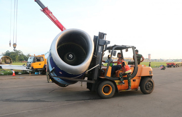 Sejumlah petugas memindahkan bagian pesawat kargo Trigana Air PK-YSF dengan rute Halim Perdanakusuma - Makassar keluar dari runway (landasan pacu) di Bandara Halim Perdanakusuma, Jakarta Timur.