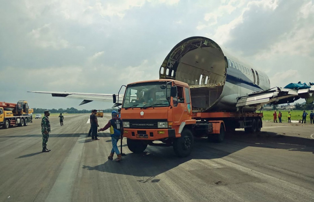 Sejumlah petugas memindahkan bagian pesawat kargo Trigana Air PK-YSF dengan rute Halim Perdanakusuma - Makassar keluar dari runway (landasan pacu) di Bandara Halim Perdanakusuma, Jakarta Timur, Minggu, 21 Maret 2021. 