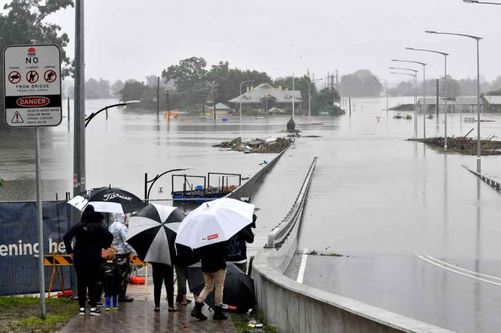 Penduduk melihat daerah permukiman yang terendam banjir di daerah Windsor di barat laut Sydney pada Selasa, 23 Maret 2021, setelah hujan lebat melanda tenggara Australia selama berhari-hari.