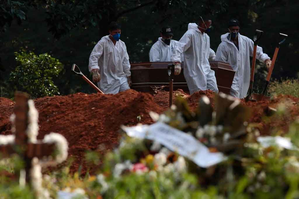 Petugas memakamkan korban covid-19 di pemakaman Vila Formosa di Sao Paulo, Brasil, pada Selasa, 23 Maret 2021 waktu setempat.