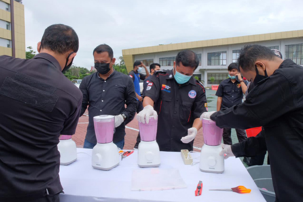 Petugas memusnahkan barang bukti narkoba dengan cara dihancurkan menggunakan blender.
