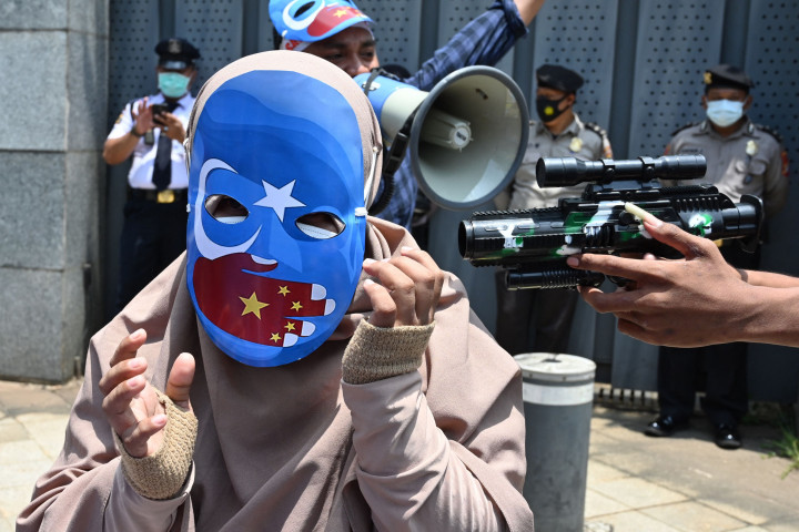 Dua orang pria yang merefleksikan pasukan militer Tiongkok tersebut tampak melakukan gerakan diskriminatif terhadap si wanita. Mereka juga terlihat membawa pistol mainan.