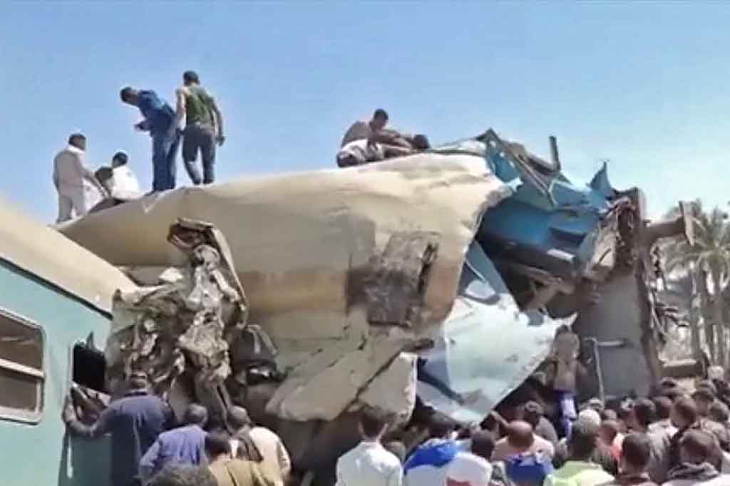 Petugas dibantu warga berusaha mengevakuasi para penumpang pascatabrakan dua kereta api di Mesir selatan, Jumat, 26 Maret 2021.
