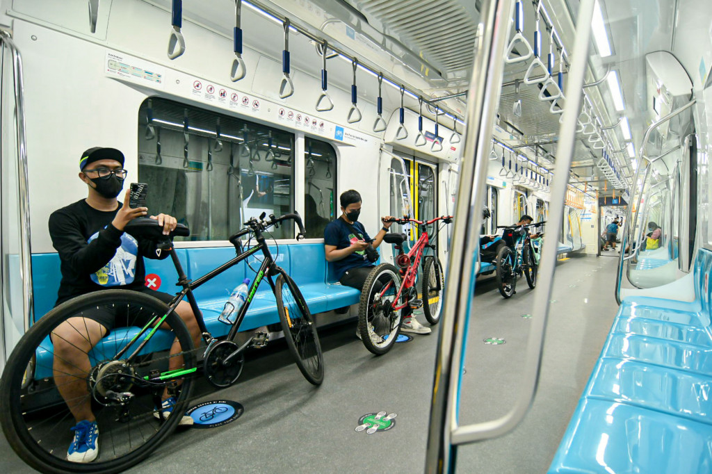 Sejumlah penumpang membawa sepeda nonlipat di dalam kereta MRT, Jakarta, Minggu, 28 Maret 2021.