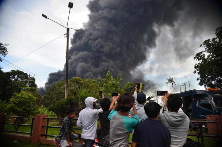 Warga mendokumentasikan terbakarnya kilang minyak Pertamina di Kawasan Balongan, Indramayu, Jawa Barat.