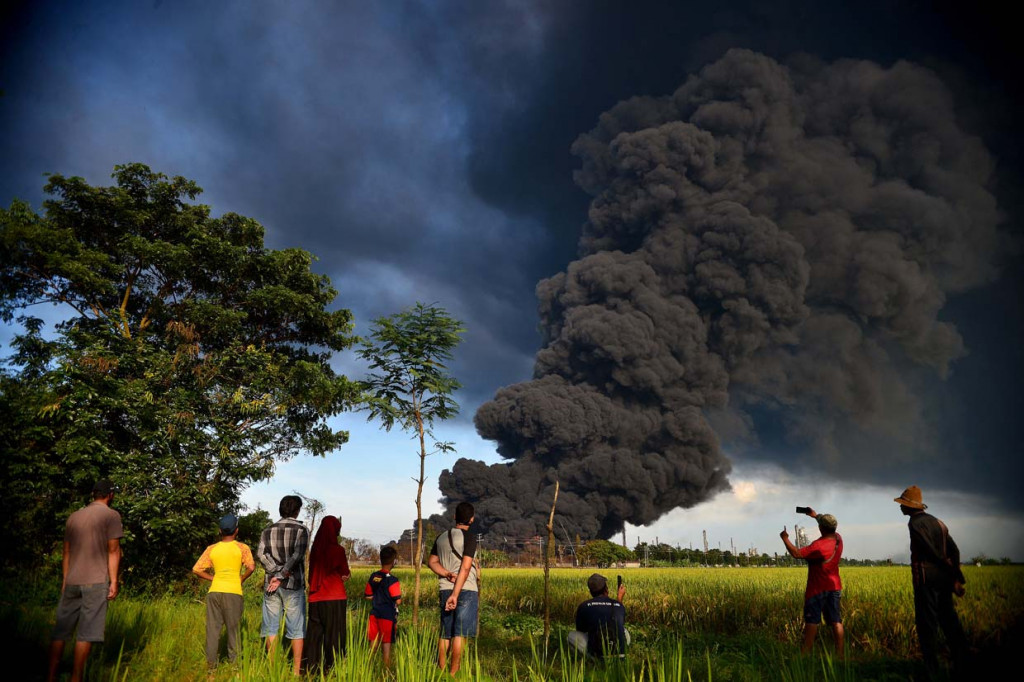 Kepulan asap hitam imbas kebakaran Kilang Pertamina RU VI Balongan Indramayu masih terlihat. Petugas juga terus berjaga di sekitar lokasi kebakaran.