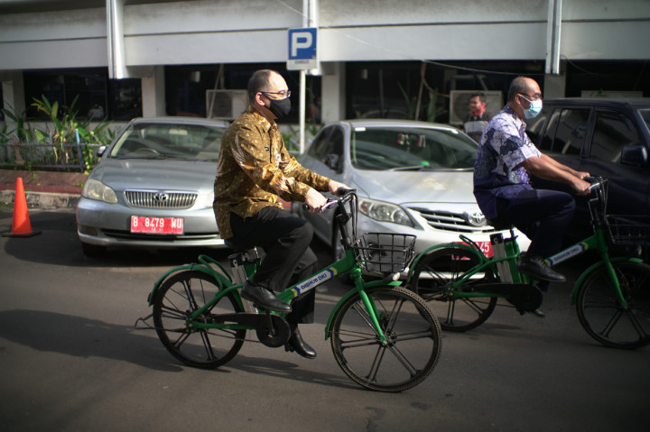 Kepala Bidang Angkutan Jalan, Dinas Perhubungan Provinsi DKI Jakarta, Kementerian Perhubungan, Republik Indonesia, Bapak Susilo Dewanto, dan Sekretaris Dinas Perhubungan Provinsi DKI Jakarta, Kementerian Perhubungan, Republik Indonesia, Bapak Massdes Arouffy mengendarai sepeda listrik GrabWheels di area parkir kantor Dinas Perhubungan (Dishub), Provinsi DKI Jakarta.