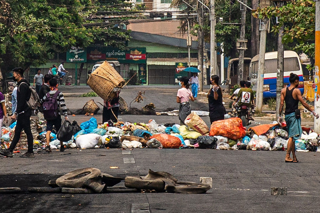 Sejumlah pengunjuk rasa membuang sampah di jalan saat demonstrasi menentang kudeta militer di Kota Thaketa Yangon, Myanmar.