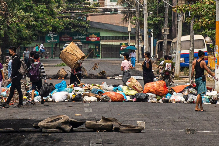 Sejumlah pengunjuk rasa membuang sampah di jalan saat demonstrasi menentang kudeta militer di Kota Thaketa Yangon, Myanmar.